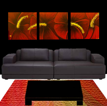 Red hibiscus triptych displayed above a leather sofa in a home interior