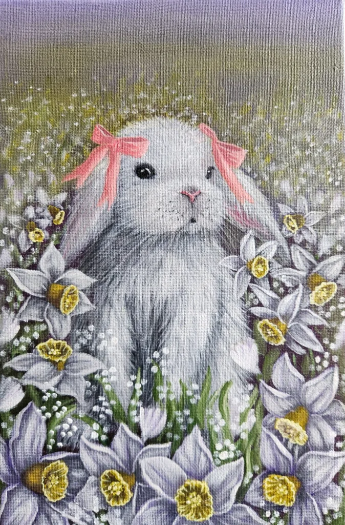 A Bunny?s Daydream painting of a white bunny with pink bows among yellow daffodils.