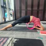 Danielle Art Original Acrylic and Oil Paintings Woman using a yoga wheel for a backbend in a yoga studio.