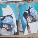 Danielle Art Original Acrylic and Oil Paintings Two watercolor paintings of cats in progress, with a blue and teal background.