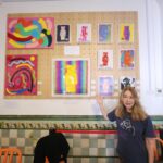 Danielle Art Original Acrylic and Oil Paintings Woman points to "Kintsugi Bear of Resilience" art series on display at gallery.