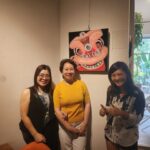 Danielle Art Original Acrylic and Oil Paintings Three women pose in front of a lion dance painting at an exhibition.