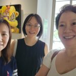 Danielle Art Original Acrylic and Oil Paintings Three smiling women, "My Besties at Art Over Coffee," posing in front of artwork.