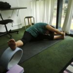 Danielle Art Original Acrylic and Oil Paintings Woman stretching on a yoga mat with a yoga wheel, returning to the mat.