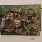 Painting of cats, birds in cages, and butterflies in a whimsical, surreal style.
