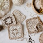 Danielle Art Original Acrylic and Oil Paintings Crocheted granny squares and yarn in neutral tones with crochet hook and scissors.