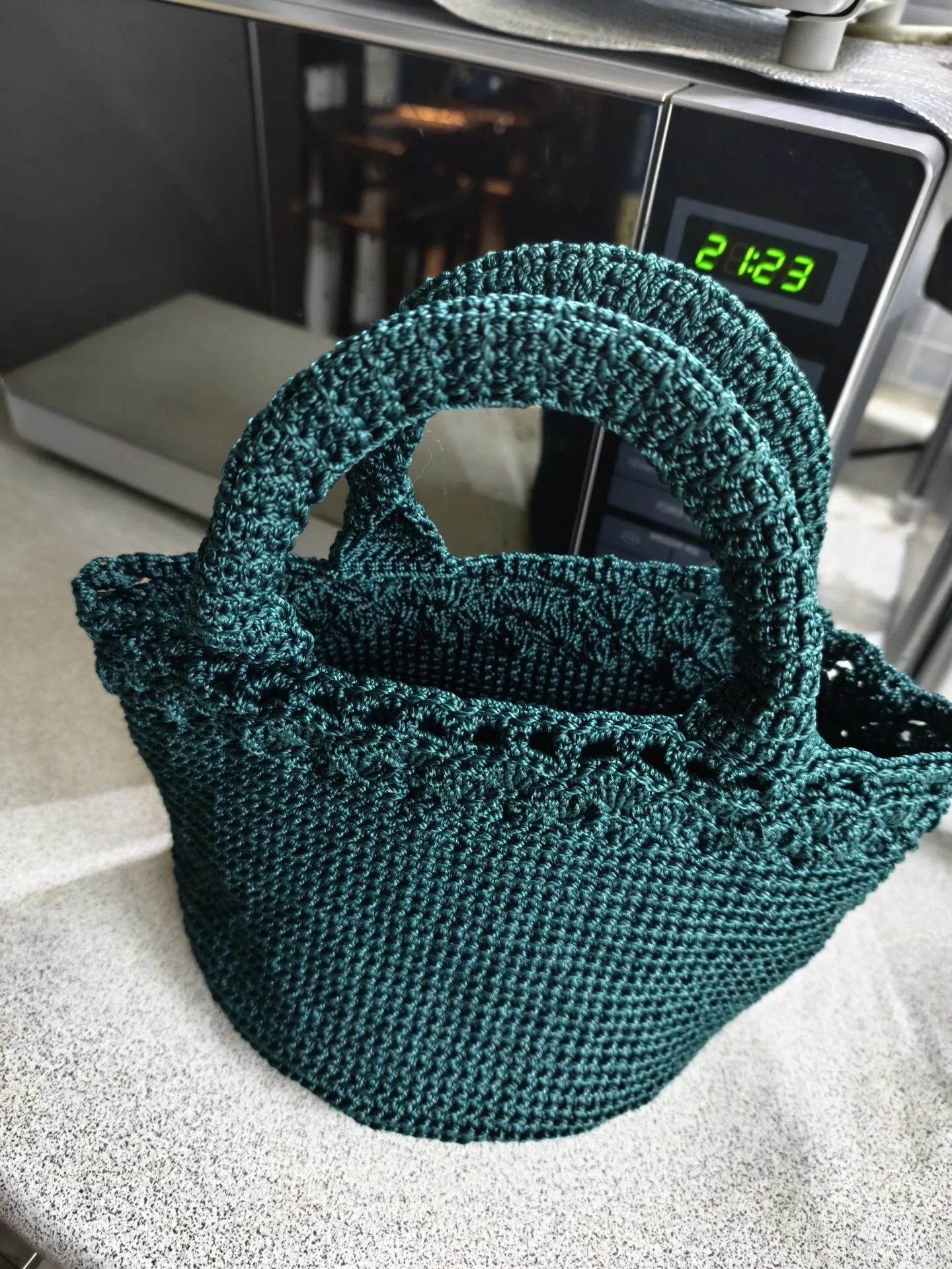 Danielle Art Original Acrylic and Oil Paintings Teal crochet potpourri pouch with handles on a countertop.